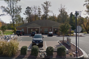 An office building and parking lot with cars parked outside