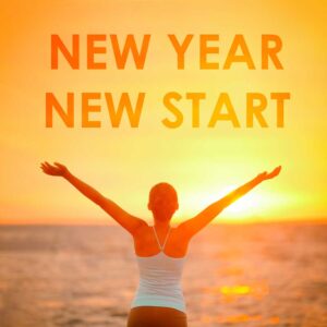 woman standing in front of ocean with arms up new year new start text