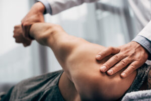 close up physician stretching arm of male patient