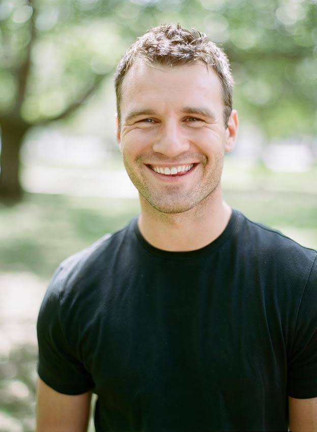 a smiling man in a black t - shirt