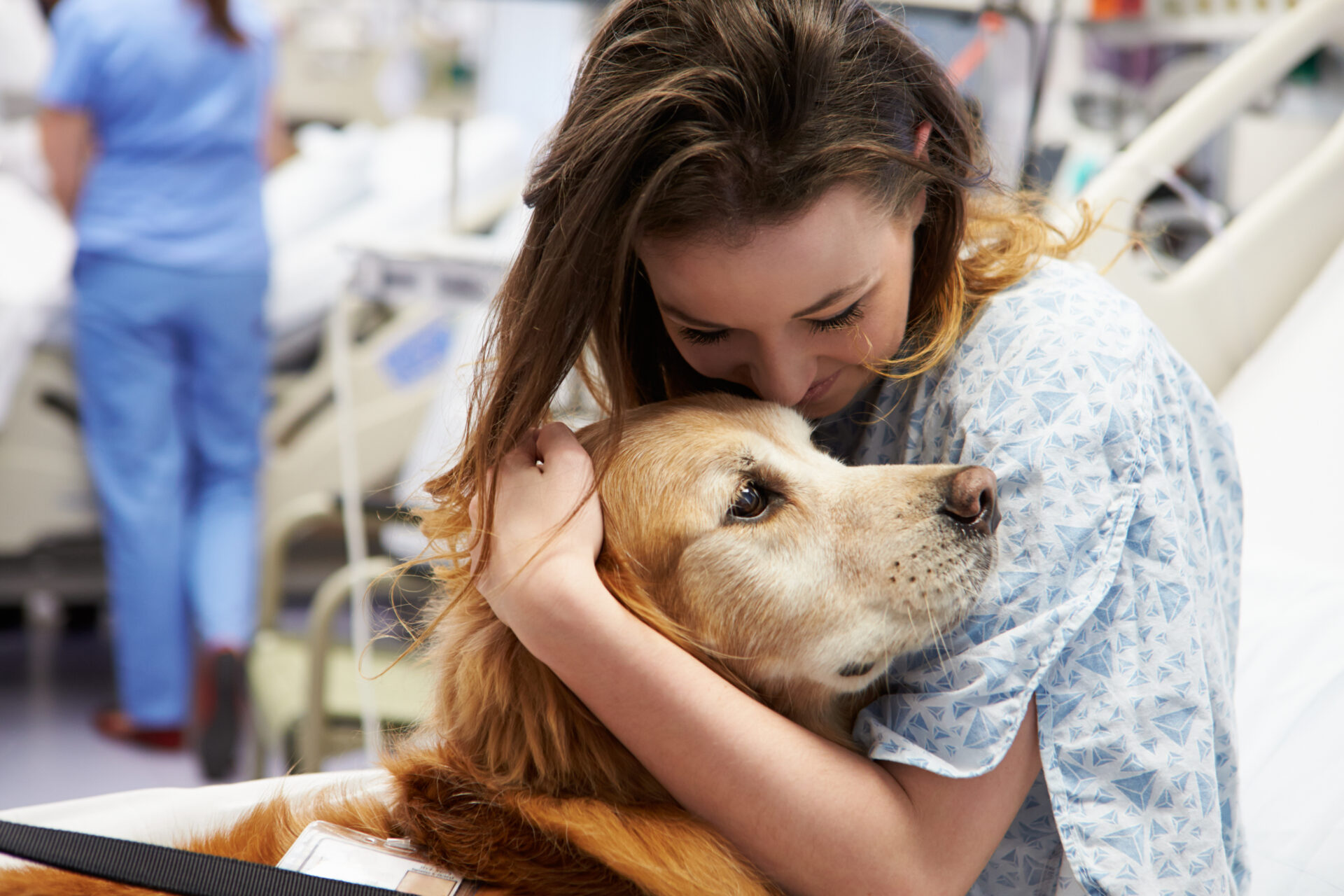 a woman hugging a dog in a hospital bed