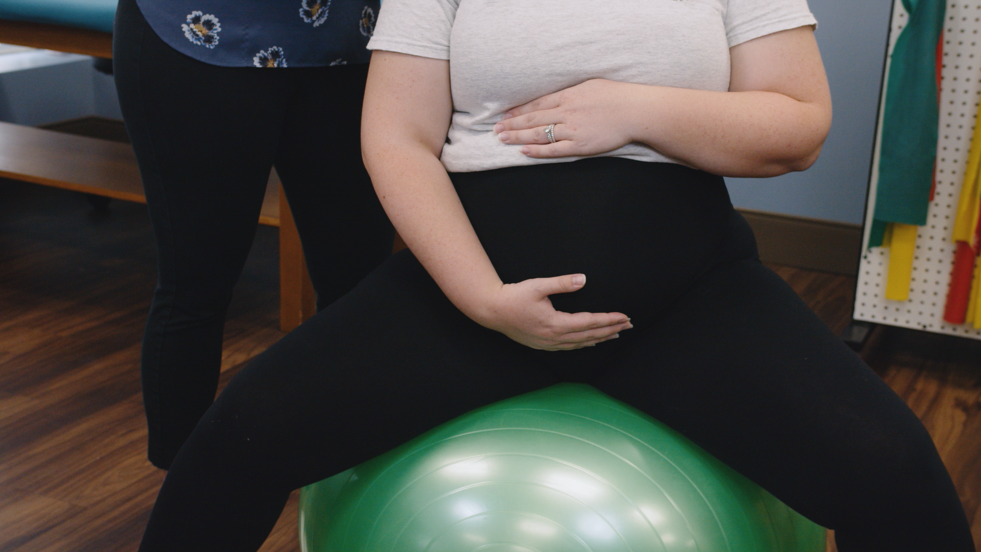 a pregnant woman sitting on an exercise ball
