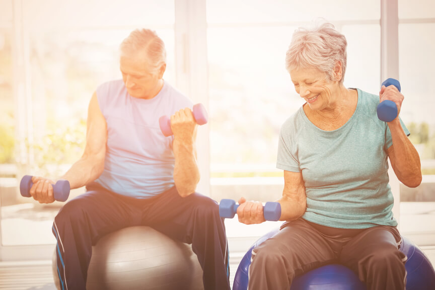 an older couple doing exercises on exercise balls