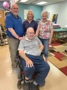 a group of people standing around a man in a wheel chair