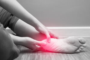 a woman is touching her foot with a red light