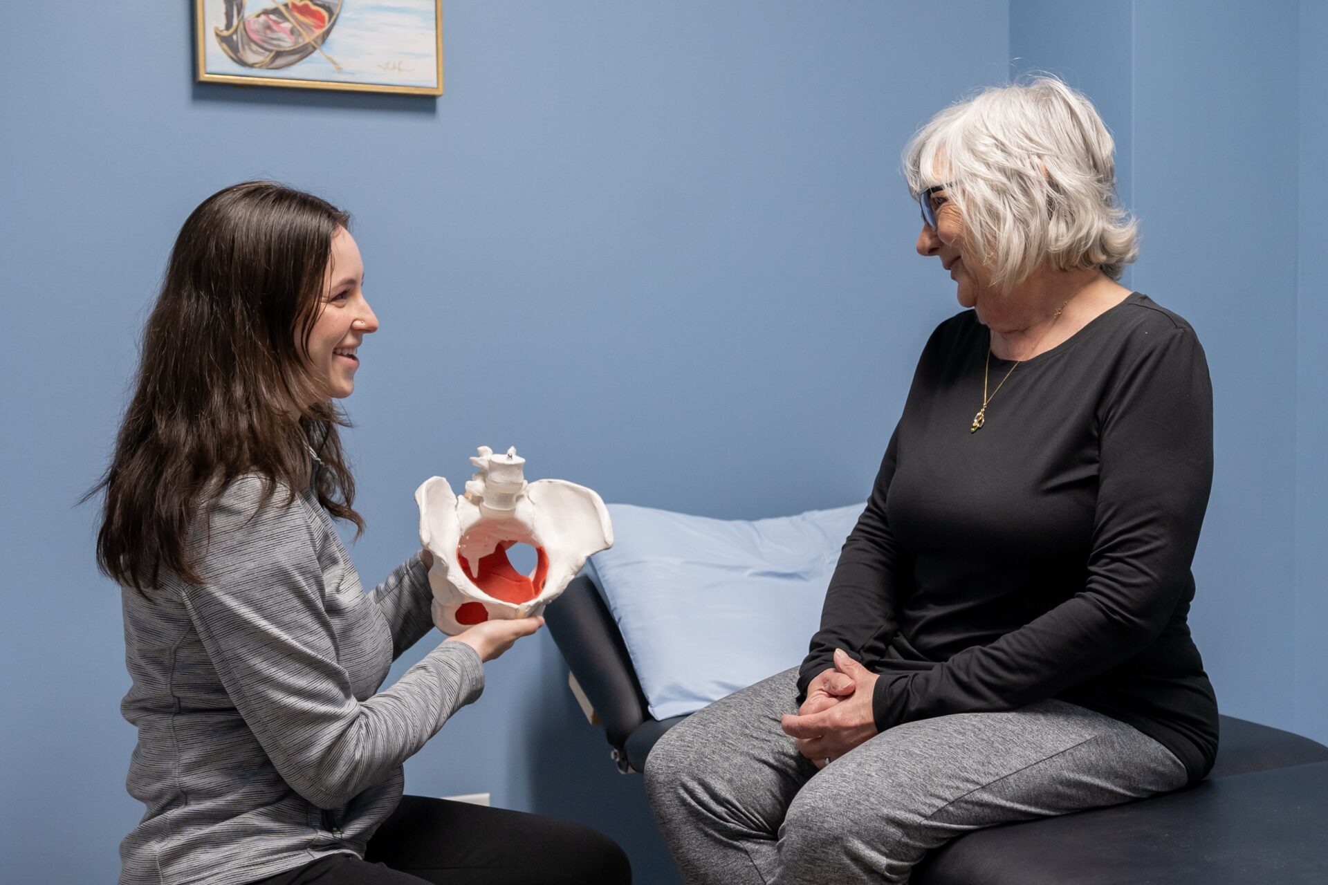 two women sitting on a bed talking to each other