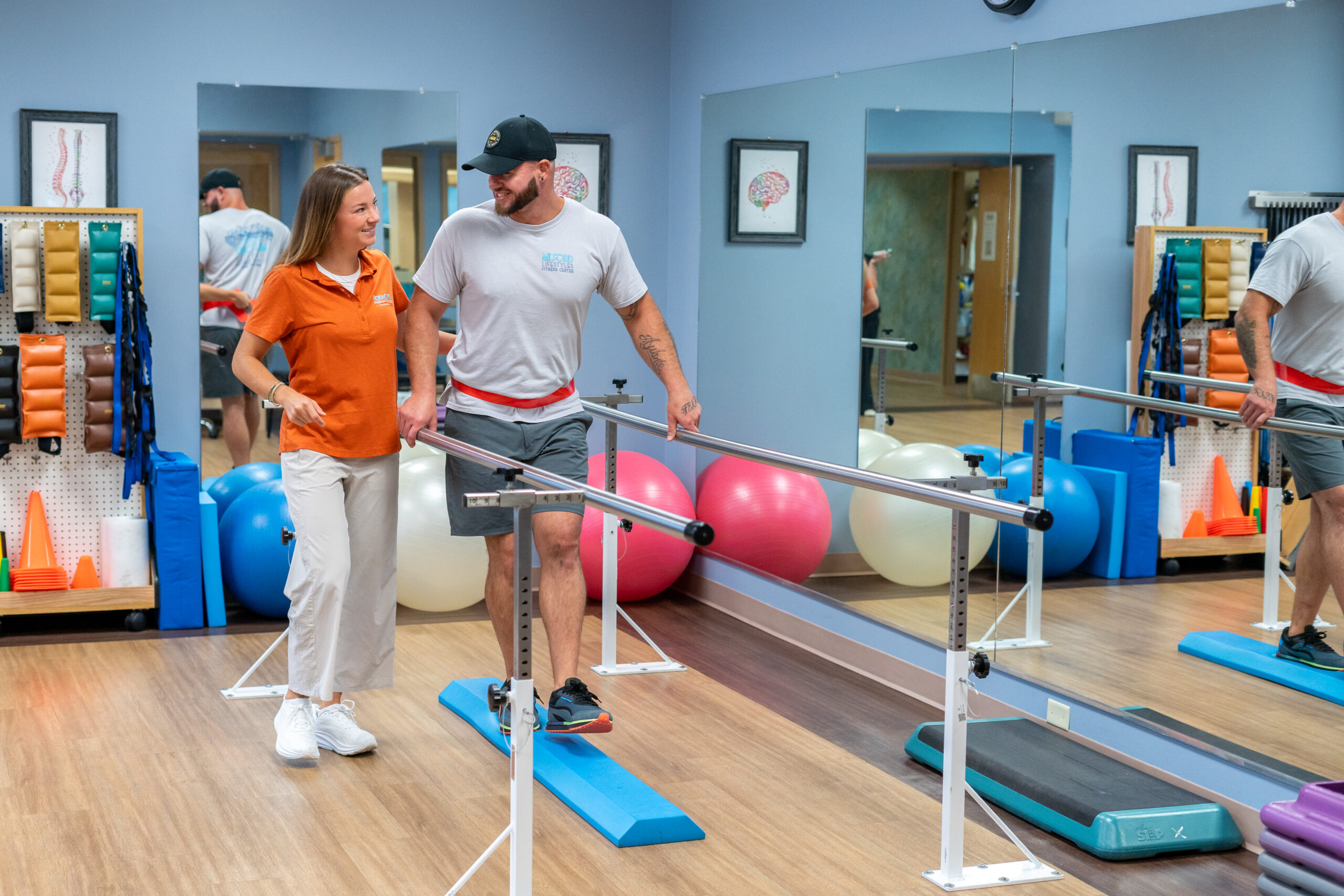 a man and woman walking on a treadmill in a gym