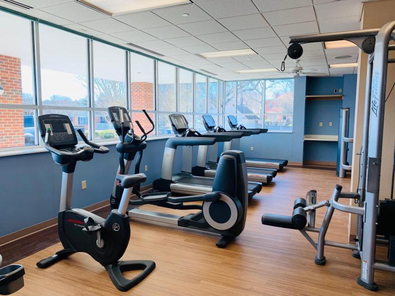 an exercise room with treadmills and windows