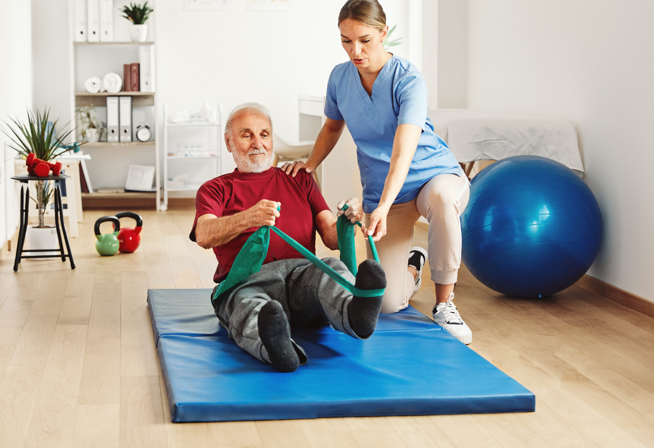 a woman helping an elderly man with exercise equipment
