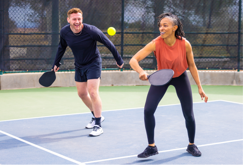 a man and woman playing pickleball on a court