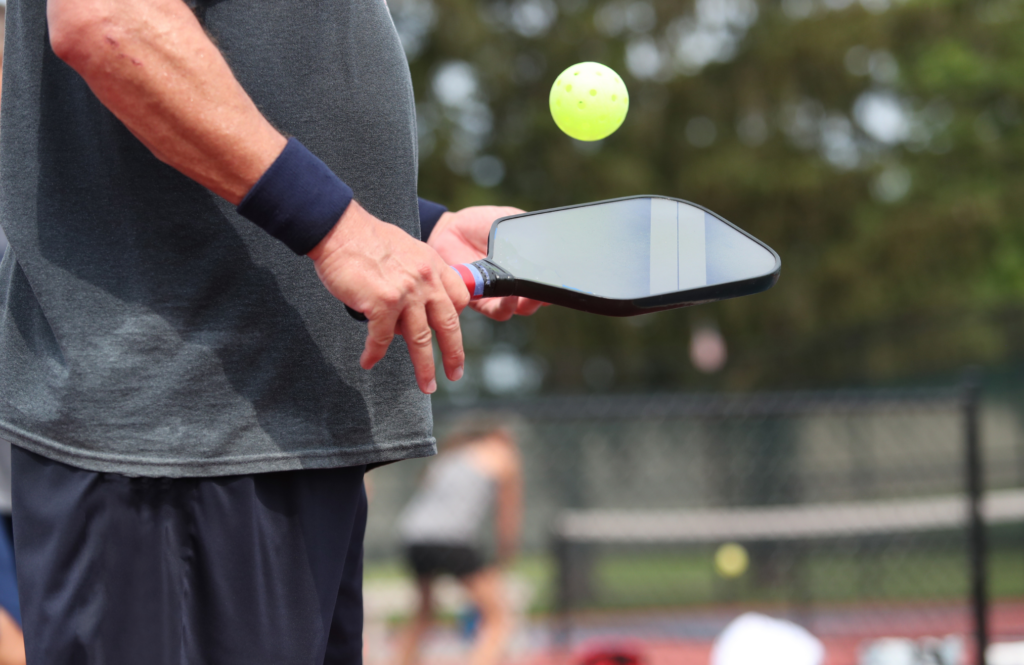 a man holding a pickleball paddle