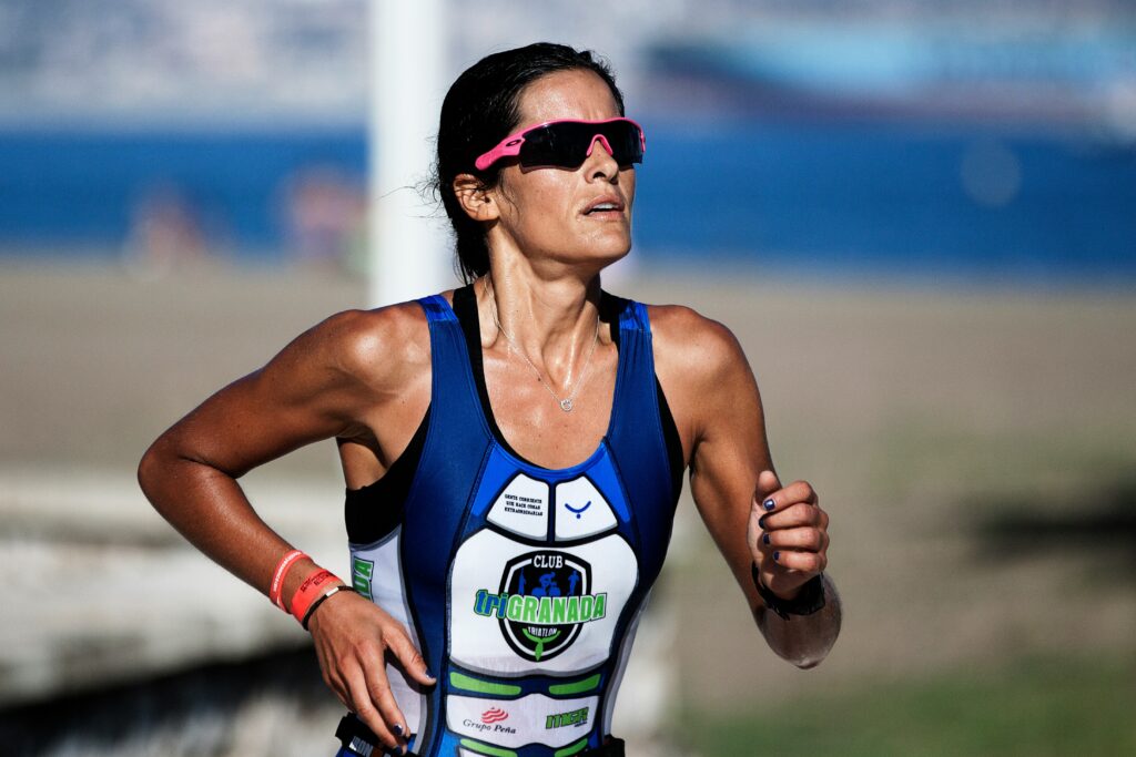 a woman running in a race wearing a blue and white suit