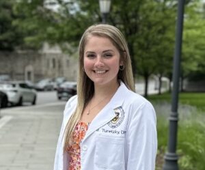 a woman in a lab coat standing on a sidewalk