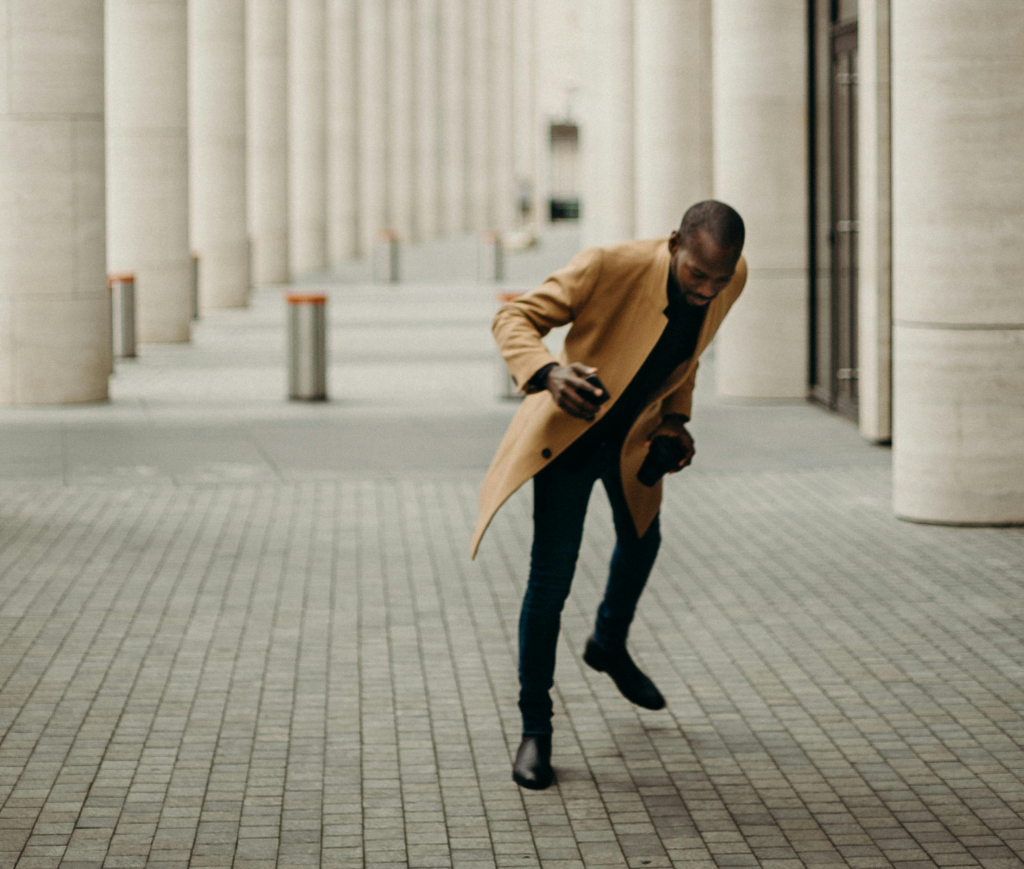 a man in a tan coat and black pants