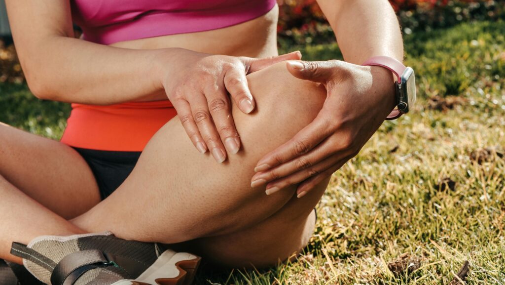 a woman sitting in the grass with her legs crossed