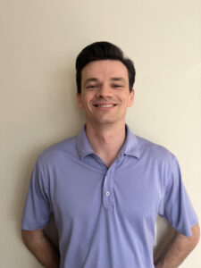 a man standing in front of a wall with his hands on his hips