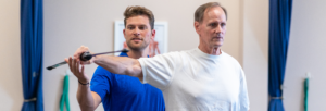 a couple of men standing next to each other in a gym