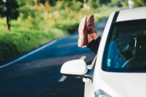 a person's feet sticking out of the window of a car