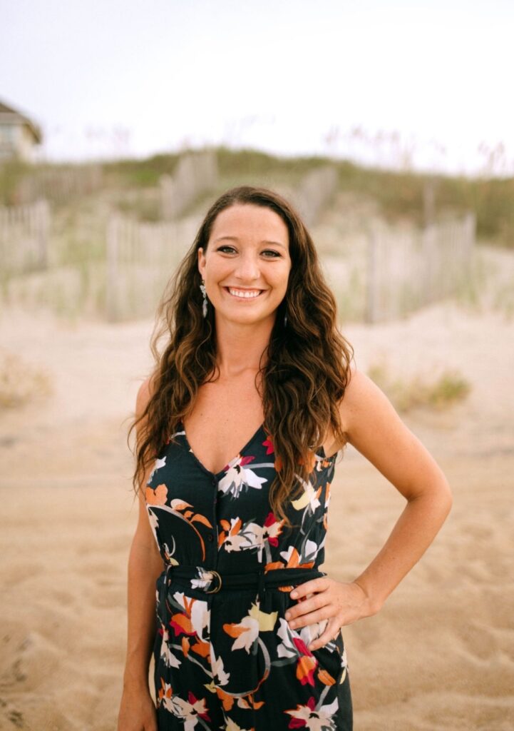 a woman standing on a beach with her hands on her hips