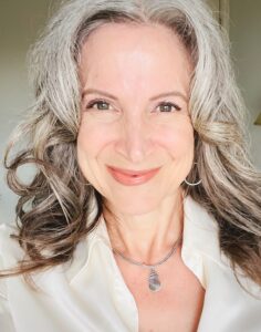 a woman with gray hair and a white shirt